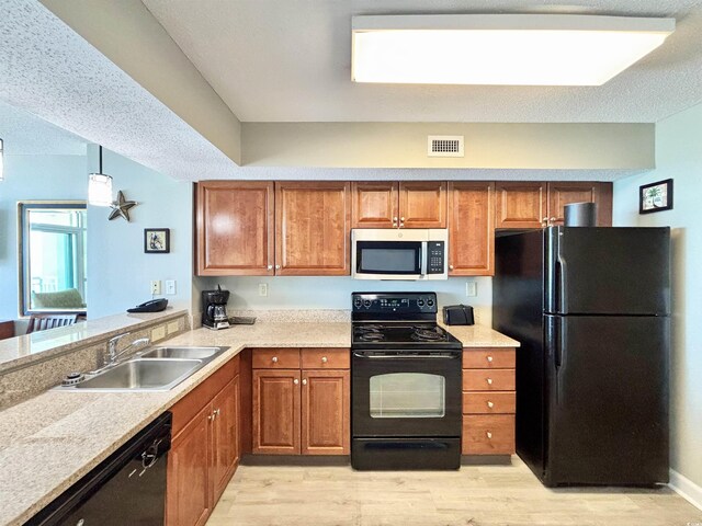 5300 N Ocean Blvd Unit 1102, Myrtle Beach, SC 29577 - kitchen featuring black appliances, a textured ceiling, a peninsula, light wood-type flooring, and brown cabinetry