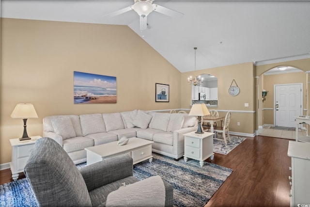 living area featuring arched walkways, a ceiling fan, dark wood-style flooring, a chandelier, and high vaulted ceiling
