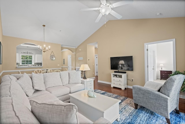 living area with arched walkways, high vaulted ceiling, dark wood-style flooring, a ceiling fan, and baseboards