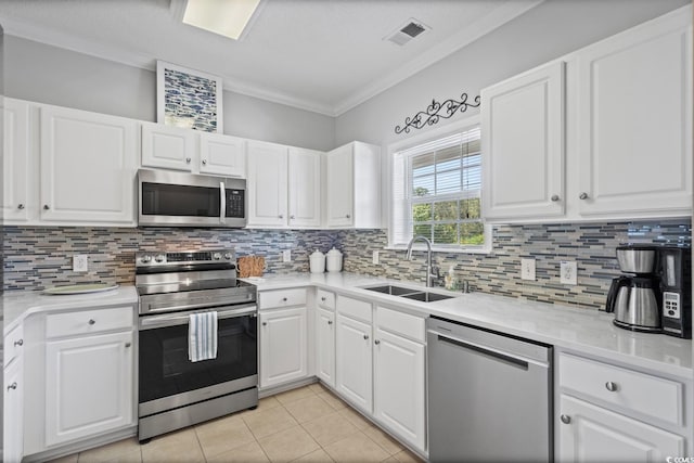 kitchen with stainless steel appliances, a sink, ornamental molding, light tile patterned flooring, and backsplash