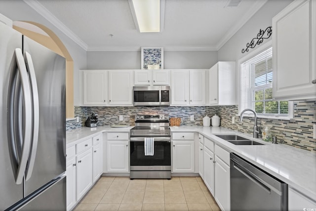 kitchen featuring appliances with stainless steel finishes, a sink, tasteful backsplash, light countertops, and crown molding