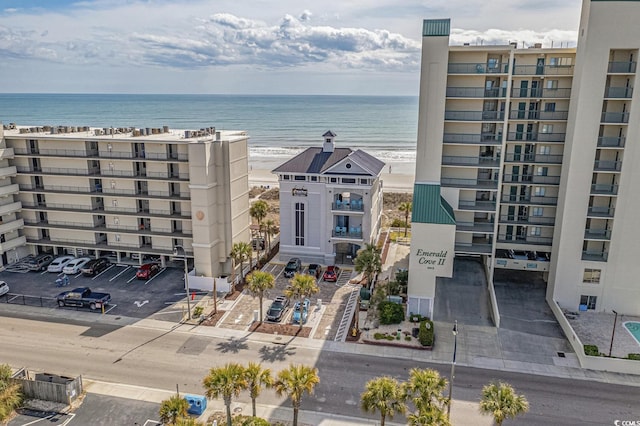 view of apartment building / complex featuring a water view and uncovered parking