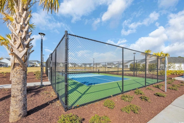 view of sport court with a tennis court and fence
