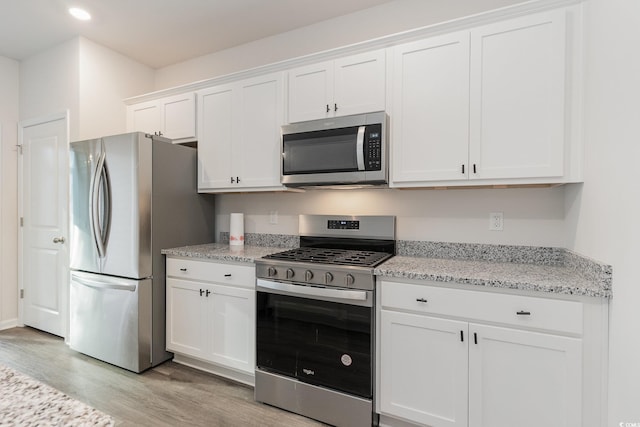 kitchen with stainless steel appliances, light wood-style flooring, white cabinetry, recessed lighting, and light stone countertops