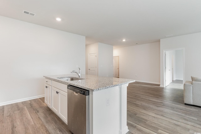 kitchen featuring stainless steel dishwasher, a sink, open floor plan, light wood-type flooring, and recessed lighting