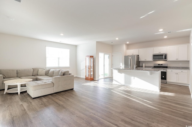 living room featuring recessed lighting, light wood-style floors, and baseboards