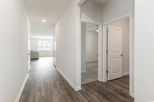 hallway with dark wood-style floors, baseboards, and recessed lighting