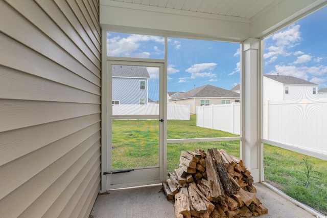 sunroom / solarium featuring plenty of natural light and a residential view