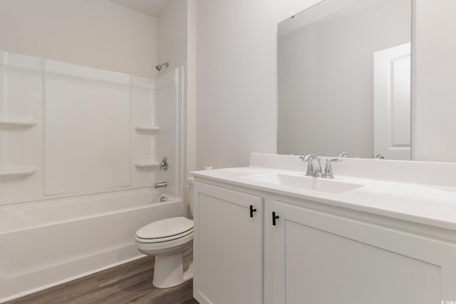 bathroom with wood finished floors, toilet, vanity, and shower / tub combination