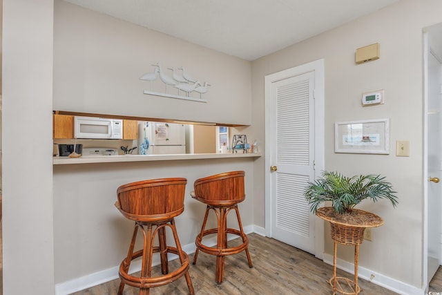 9661 Shore Dr Unit B-3, Myrtle Beach, SC 29572 - bar featuring white appliances, wood finished floors, and baseboards