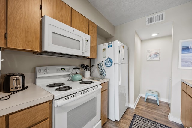 9661 Shore Dr Unit B-3, Myrtle Beach, SC 29572 - kitchen with white appliances, light wood-style flooring, light countertops, a textured ceiling, and baseboards