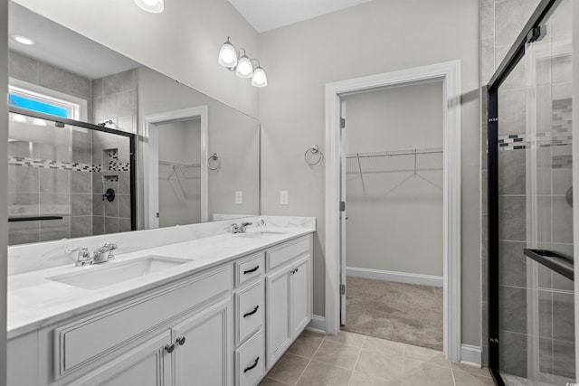 1808 Zodiac Ct, Myrtle Beach, SC 29577 - bathroom with a walk in closet, double vanity, a stall shower, tile patterned floors, and baseboards