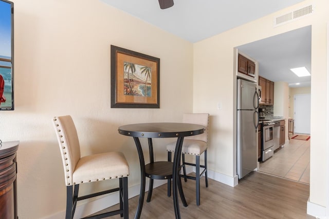 7509 N Ocean Blvd Unit 404, Myrtle Beach, SC 29572 - dining area featuring baseboards, light wood-type flooring, and a ceiling fan