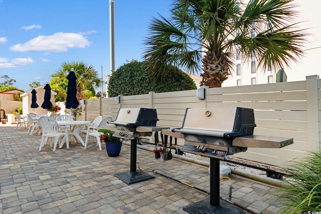 7509 N Ocean Blvd Unit 404, Myrtle Beach, SC 29572 - view of patio featuring fence, a grill, and outdoor dining space