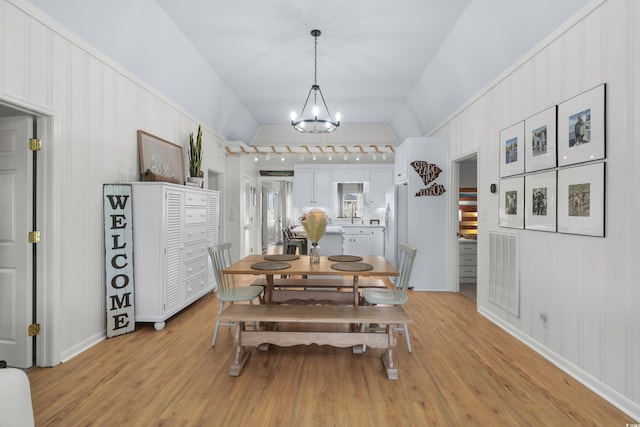 337 59th Ave N, North Myrtle Beach, SC 29582 - dining space with a chandelier, light wood-style floors, lofted ceiling, and baseboards