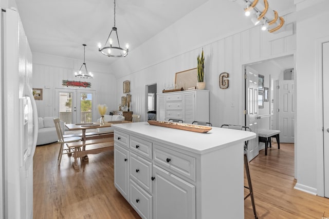 337 59th Ave N, North Myrtle Beach, SC 29582 - kitchen featuring white refrigerator with ice dispenser, a chandelier, a breakfast bar area, open floor plan, and light wood finished floors