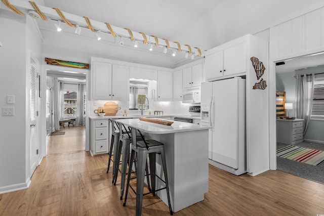 337 59th Ave N, North Myrtle Beach, SC 29582 - kitchen featuring white appliances, light wood finished floors, light countertops, and plenty of natural light