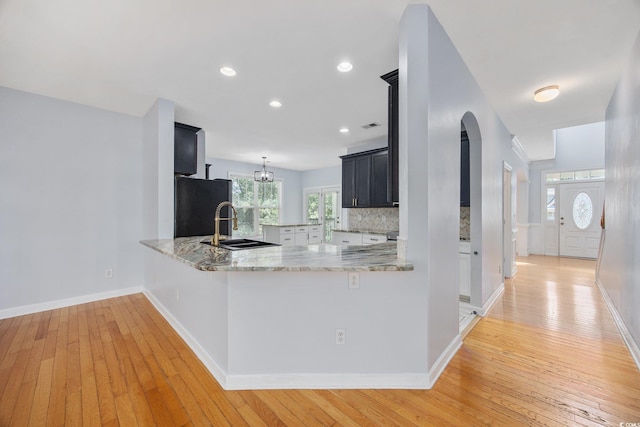 854 Falkirk St, Myrtle Beach, SC 29579 - kitchen with fridge, light wood-type flooring, dark cabinetry, light stone countertops, and a sink