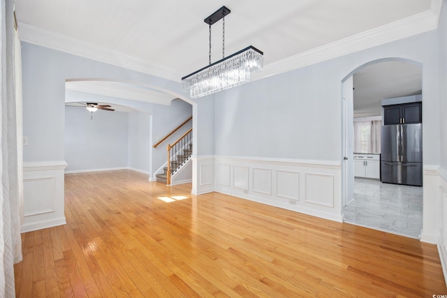 854 Falkirk St, Myrtle Beach, SC 29579 - unfurnished dining area featuring arched walkways, crown molding, ceiling fan, stairway, and wainscoting