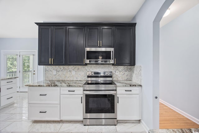 854 Falkirk St, Myrtle Beach, SC 29579 - kitchen with appliances with stainless steel finishes, light stone countertops, tasteful backsplash, and dark cabinets