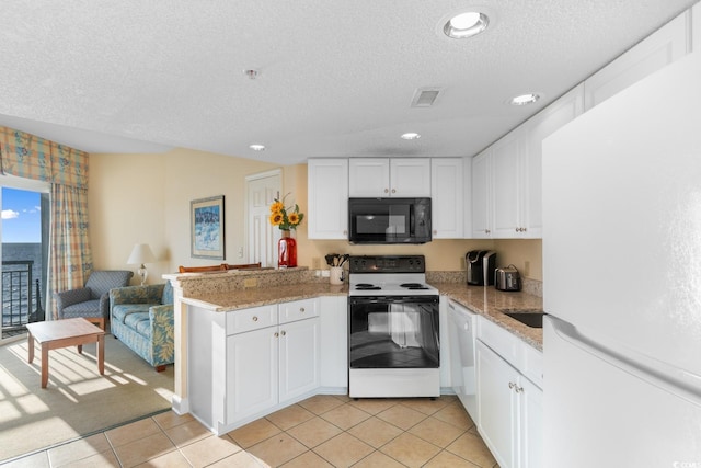 2501 S Ocean Blvd Unit 831, Myrtle Beach, SC 29577 - kitchen with freestanding refrigerator, black microwave, electric range oven, a peninsula, and a textured ceiling