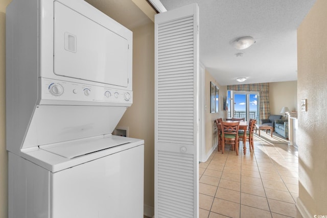 2501 S Ocean Blvd Unit 831, Myrtle Beach, SC 29577 - washroom with stacked washing machine and dryer, light tile patterned floors, and baseboards