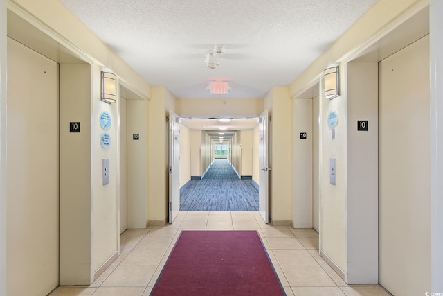 2501 S Ocean Blvd Unit 831, Myrtle Beach, SC 29577 - corridor featuring elevator, light tile patterned floors, a textured ceiling, and baseboards