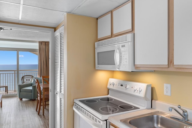 2000 Ocean Blvd N Unit Ph11, Myrtle Beach, SC 29577 - kitchen featuring white appliances, a sink, a water view, wood finished floors, and light countertops