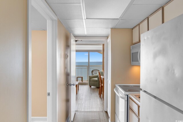 2000 Ocean Blvd N Unit Ph11, Myrtle Beach, SC 29577 - kitchen featuring white appliances, a paneled ceiling, light wood finished floors, and a water view