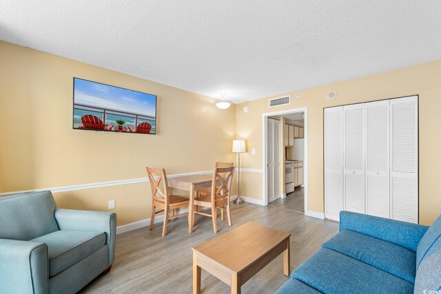 2000 Ocean Blvd N Unit Ph11, Myrtle Beach, SC 29577 - living area featuring a textured ceiling, wood finished floors, and baseboards