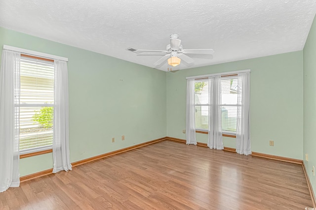 934 Tiffany Ln, North Myrtle Beach, SC 29582 - unfurnished room with light wood finished floors, baseboards, ceiling fan, and a textured ceiling