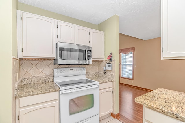 934 Tiffany Ln, North Myrtle Beach, SC 29582 - kitchen featuring stainless steel microwave, white electric range oven, tasteful backsplash, and white cabinetry