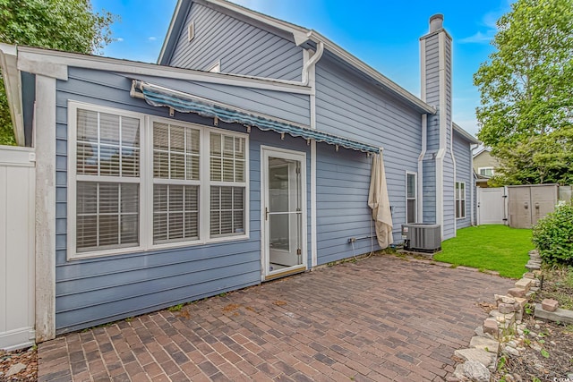 934 Tiffany Ln, North Myrtle Beach, SC 29582 - back of house featuring a patio, a gate, central air condition unit, and a chimney