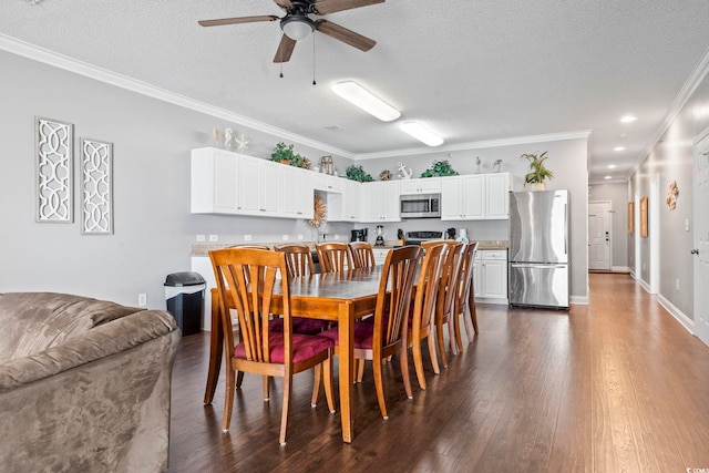 dining area featuring a ceiling fan, a textured ceiling, dark wood-style floors, ornamental molding, and baseboards