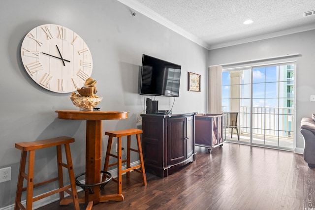 living area featuring a textured ceiling, dark wood finished floors, and ornamental molding