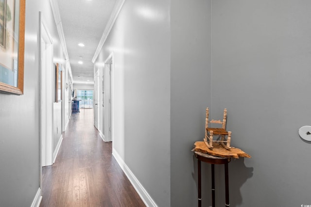 hallway featuring ornamental molding, dark wood-style floors, baseboards, and recessed lighting