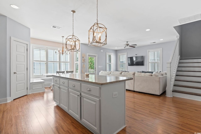 kitchen featuring a chandelier, a center island, healthy amount of natural light, wood finished floors, and recessed lighting