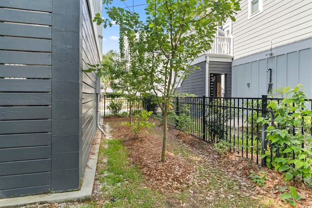 view of yard with fence and a balcony