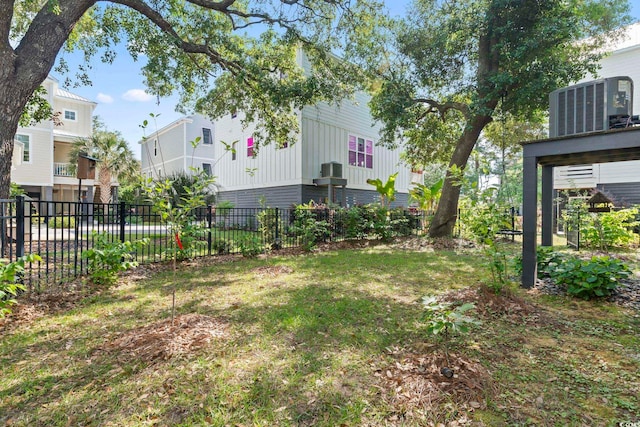 view of yard with central AC and fence