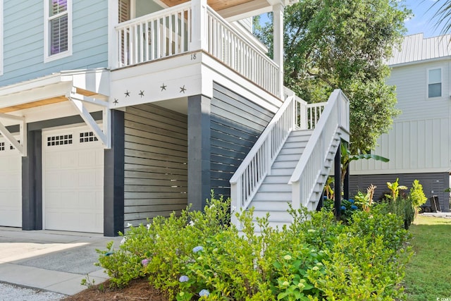 property entrance with an attached garage, a balcony, and concrete driveway