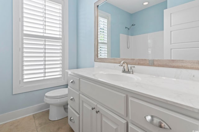 bathroom featuring tile patterned flooring, baseboards, toilet, vanity, and a shower