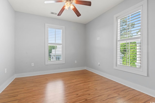 unfurnished room with wood finished floors, a ceiling fan, and baseboards