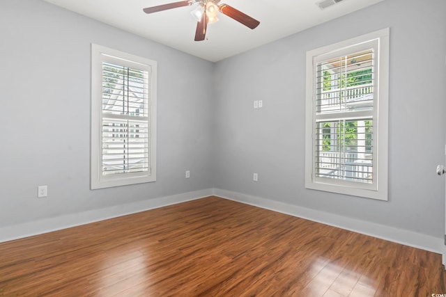 empty room featuring wood finished floors, ceiling fan, and baseboards