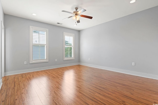 spare room featuring wood finished floors, baseboards, a ceiling fan, and recessed lighting