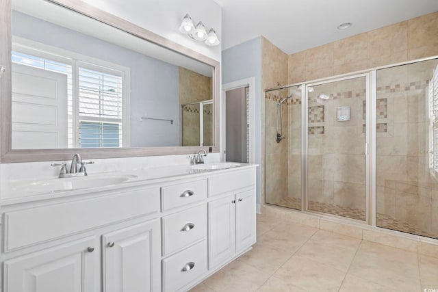 bathroom with a stall shower, tile patterned floors, and double vanity