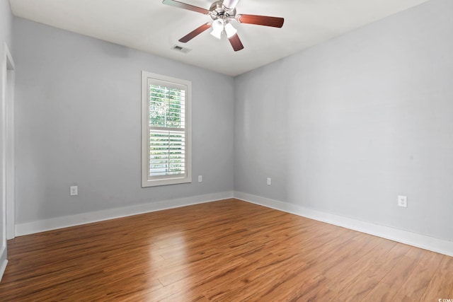 unfurnished room with wood finished floors, a ceiling fan, and baseboards