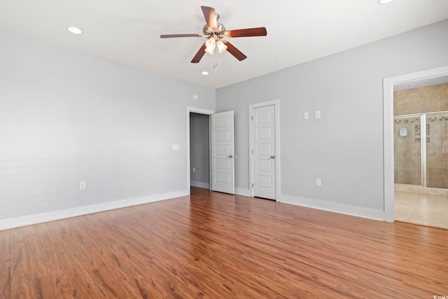 unfurnished bedroom with wood finished floors, baseboards, recessed lighting, connected bathroom, and ceiling fan