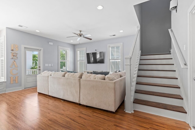 living area with a ceiling fan, wood finished floors, stairway, and recessed lighting