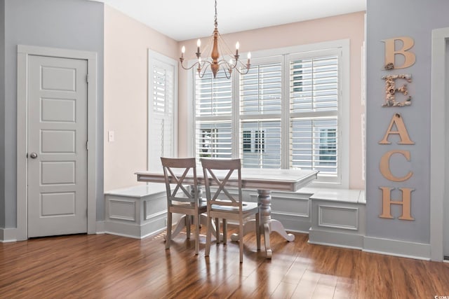 dining space featuring a chandelier, wood finished floors, and baseboards