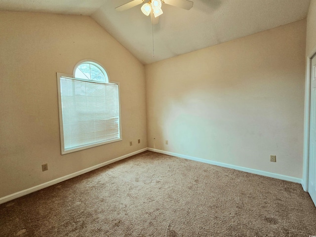 unfurnished room featuring carpet, a ceiling fan, vaulted ceiling, and baseboards